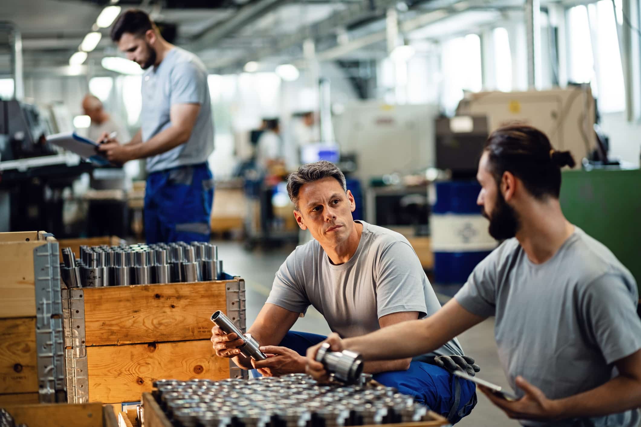 Steel workers communicating during quality control inspection at industrial facility. Quality Control